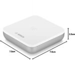 Flacher weisser Bosch Smart Home Wassermelder auf dem Boden neben einer Waschmaschine