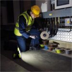 Flache LED-Arbeitsleuchte von LE mit grünen Gummikanten und rastendem Klappgriff