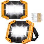 Zwei orange-schwarze LED-Akku-Baustrahler mit COB-Leuchtfeld und zwei USB-Ladekabeln