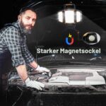 Leuchte magnetisch an einer Motorhaube befestigt, Mechaniker arbeitet darunter