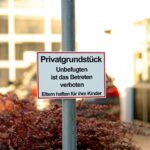 Warnschild Privatgrundstueck an Rundrohrmast am Grundstueckseingang