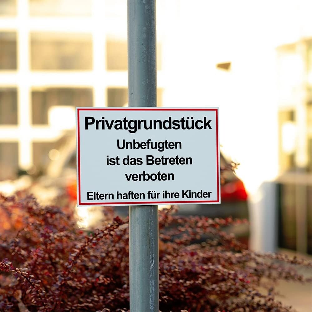 Anwendungsfoto Schild am grauen Rundrohrmast montiert, roter Warnschild Privatgrundstueck an Rundrohrmast am Grundstueckseingang