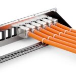 Keystone Module eingeschnappt in ein 19 Zoll Leerpanel mit orangen Verlegekabeln