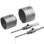 Zwei Bohrkronen 68 und 82 Millimeter mit Zentrierbohrern und Adaptern auf weissem Grund