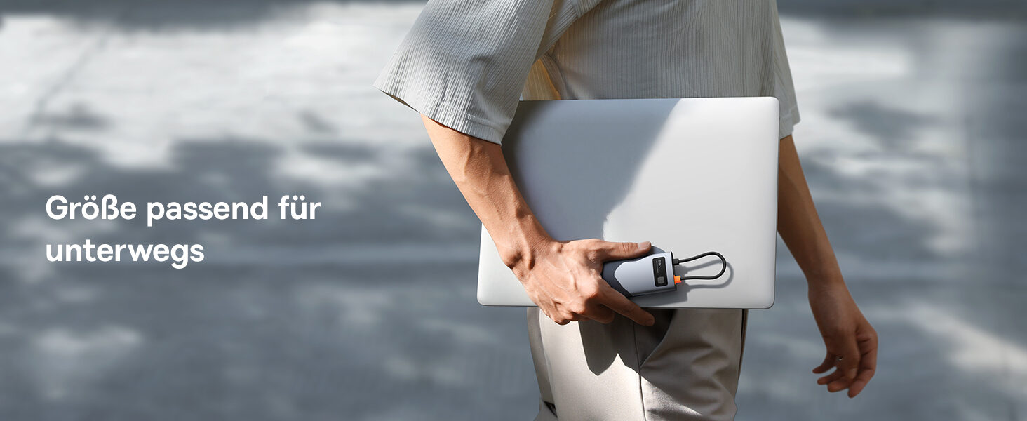 Person traegt Laptop und den kompakten Hub in der Hand