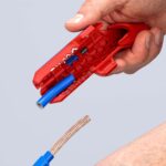 ErgoStrip isoliert eine blaue Einzeladerleitung ab, der abisolierte Kupferleiter liegt daneben