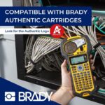 Brady M210 Etikettendrucker mit ABC-Tastatur, LCD-Anzeige und eingelegter Etikettenpatrone.