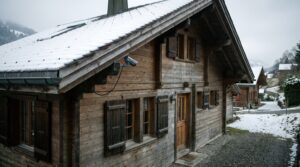 Sicherheitskamera unter dem Dachvorsprung eines Schweizer Ferienhauses im Winter