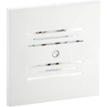 Weisse quadratische Unterputz-Abdeckung mit Schallschlitzen, dahinter die Metallglocke des Läutewerks Honeywell Home E2609