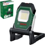 Grün-schwarze Bosch Akku-Arbeitsleuchte UniversalWorkLight 18V-2100 mit LED-Lichtfeld, aufgeklapptem Standbügel und Tragegriff, daneben der grüne Verkaufskarton