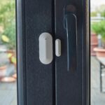 Weisser Safe2Home Funk-Magnetkontakt mit separatem Magnet und roter Melde-LED, montiert am Fensterflügel