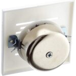Weisse quadratische Unterputz-Abdeckung mit Schallschlitzen, dahinter die Metallglocke des Läutewerks Honeywell Home E2609