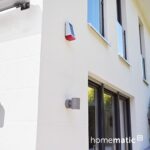 Weisse Homematic IP Aussensirene mit Solarzelle auf der Front und rotem Signalfeld am Fuss